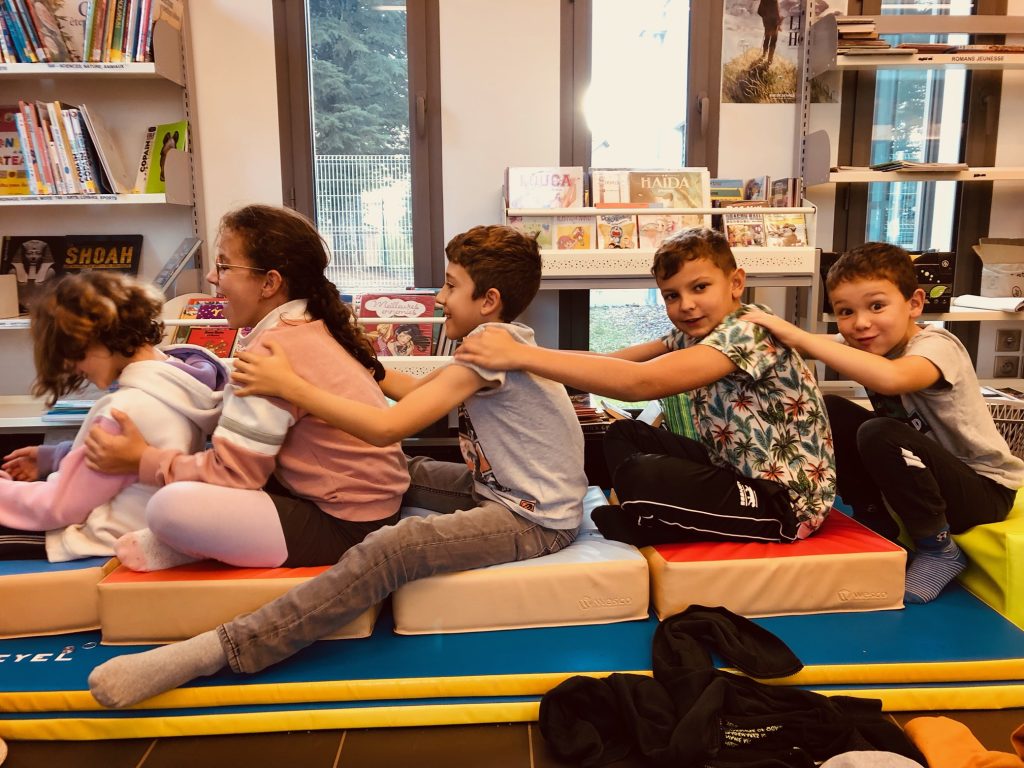 Les enfants de l'école de Lunan réalisent le Massage Météo à la bibliothèque municipale, dans le cadre des ateliers philo, massage et lecture.